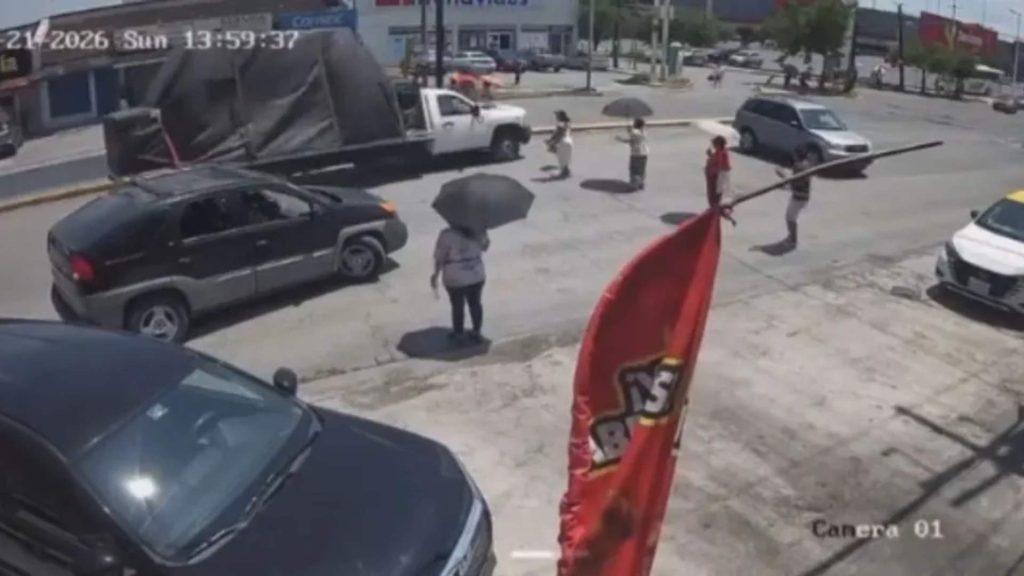 Surveillance Image of a Street Corner with Parked Cars, Several Pedestrians (one with an Umbrella) and a Red Flag in the Foreground. › Guadalupa Ciudadana