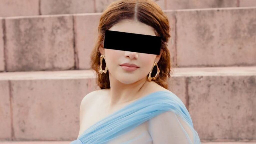 Bloque 0 40 › Guadalupa Ciudadana Portrait of a Woman in a Light Blue Draped Dress on Stone Steps; Eyes Are Covered with a Black Bar for Privacy. › Guadalupa Ciudadana
